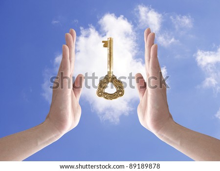 the key to success (hand holding key against blue sky)