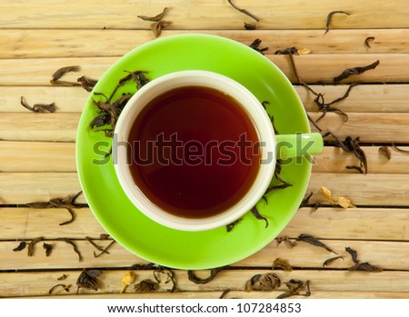 green cup of hot tea on wood background