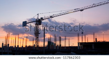 Industrial construction cranes and building at night