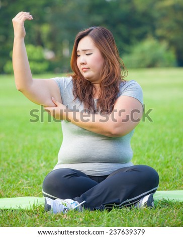 Young asian fat woman checking her arm fat