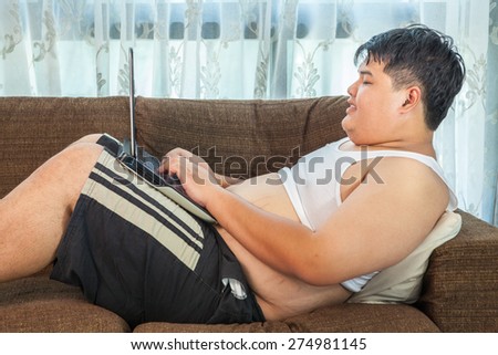 Asian fat man using laptop in home