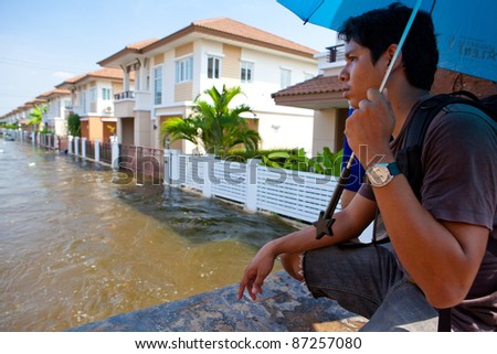 BANGKOK - OCTOBER 24:  An unidentified man looks at his flooded house on of October 24, 2011 in Bangkok, Thailand. The area is flooded due to recent monsoons.