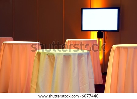Tables and a flatscreen TV in a business-like environment.