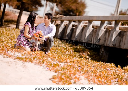 Pre wedding bride and groom sit down at the beach