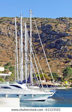 White yachts or sailbouts on an anchor in harbor - in background you can see a rocky mountain