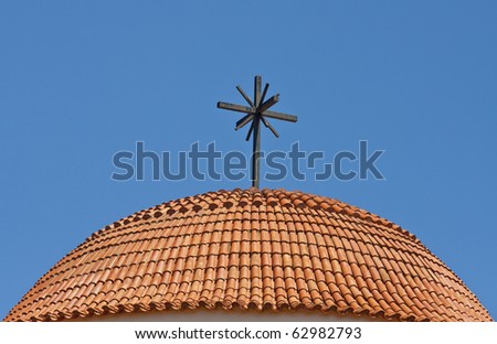 round roof of a church - covered with tiles and cross