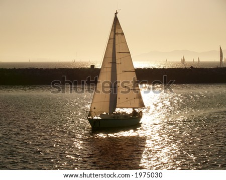 Sailboat near sunset with light through sails