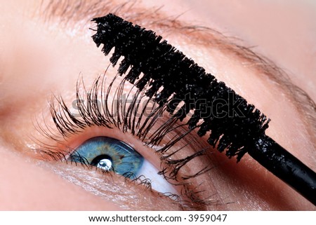 the girl is putting a mascara on eye lashes