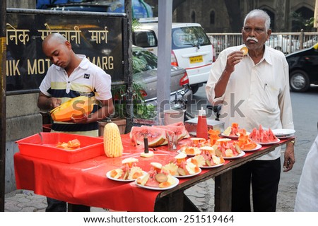 MUMBAI, INDIA- 5 January 2015: Vendor sells fruit salad in a street on Mumbai. According to the Food and Agriculture Organization, 2.5 billion people eat street food every day