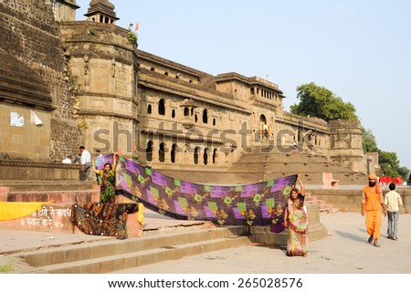 Maheshwar, India - 3 February 2015: Woman drying them sari in front of Maheshwar palace, India