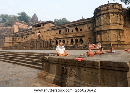 Maheshwar, India - 4 February 2015: People doing yoga and meditation in front of Maheshwar palace on India