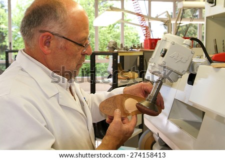 Locarno, Switzerland: 4 May 2010: Doctor preparing orthopedic insoles for a patient on his workshop