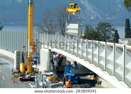 Bissone, Switzerland - 18 March 2010: Workers during the installation of noise barriers on the highway at Bissone on Switzerland