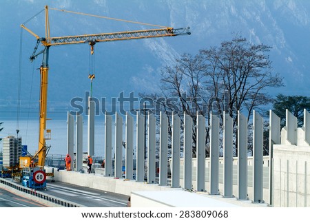 Bissone, Switzerland - 12 March 2010: Workers during the installation of noise barriers on the highway at Bissone on Switzerland