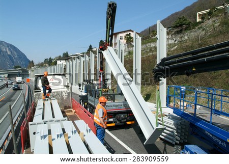 Bissone, Switzerland - 7 April 2010: Workers during the installation of noise barriers on the highway at Bissone on Switzerland