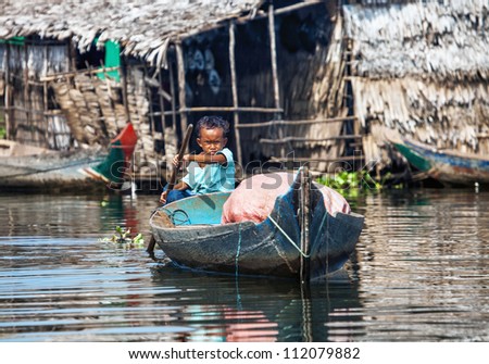 SIEM REAP, CAMBODIA-NOVEMBER 17: An unidentified boy on a boat floating on Tonle Sap lake in Siem Reap, Cambodia on November 17, 2011. Tonle Sap is the largest lake in SE Asia peaking at 16kkm2