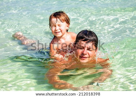 Father and son swimming in the tropical sea