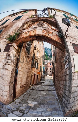 Fish-eye lens look of the old city on sky background. Kotor. Montenegro. Signs on the walls indicate the entrance to the old fortress