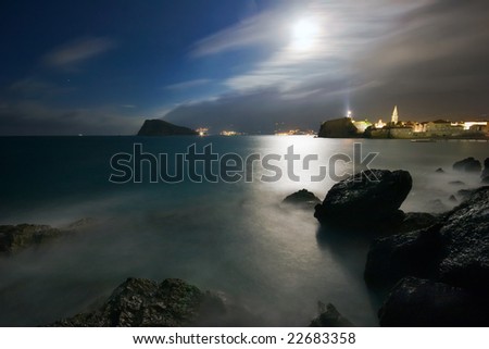 Night landscape with the sea, the moon and rocks. It is photographed in Montenegro in September. The city of Budva. Adriatic sea.