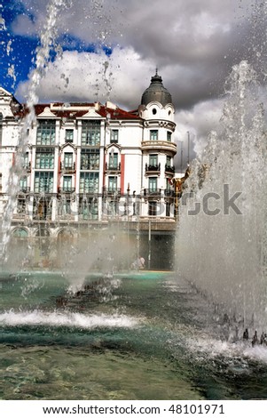 The jet fountain on old building and sky background