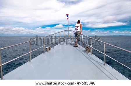 A man stands on the bow of the ship and looks at sea. Andaman sea. Thailand Kingdom.