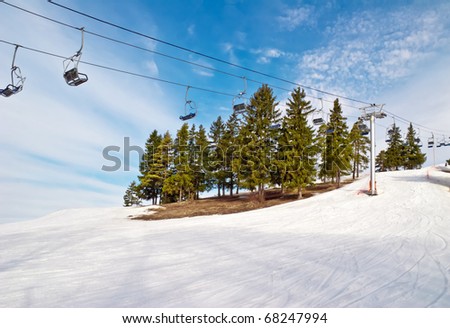 Ski lift chairs on blue sky background