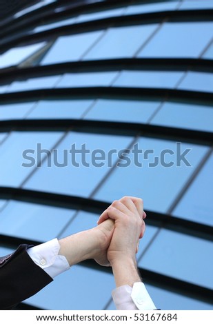 hands of a businessman in the air  in front of business building , business success concept