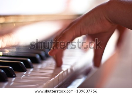 Children\'s fingers on the keys of a piano playing/Etude