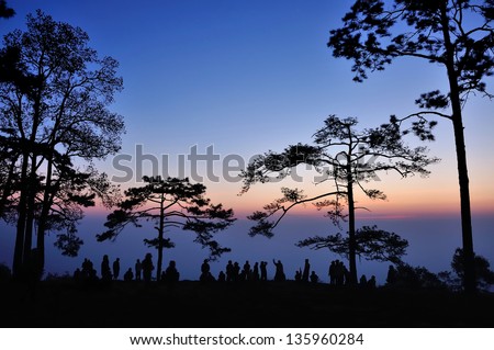 Silhouette of people waiting for sunrise in dawn at Makdook cliff, Thailand.