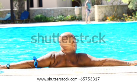 Big bald man relax in swimming pool