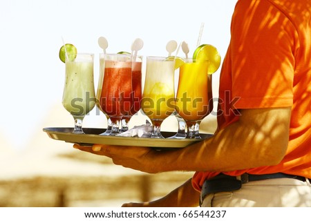 Waiter serving drinks / cocktails on the beach