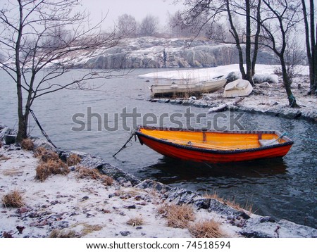 Orange fishing boat in winter in Finland
