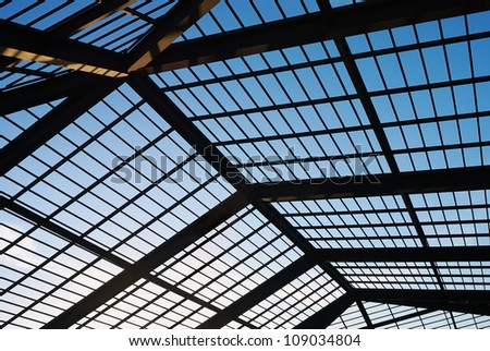 the roof structure of  building against a clear blue sky in the background