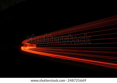 Abstract red rays of light in a car tunnel