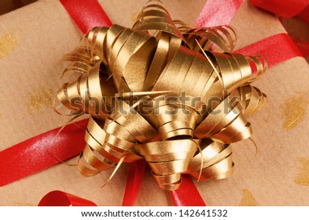 Closeup of a Christmas present with red and golden ribbon