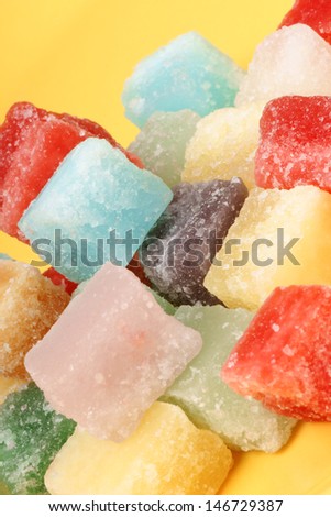 Colorful mixed fondant candies over a yellow background. Selective soft focus.