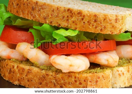 Close-up of a sandwich with shrimps, pesto, lettuce and tomato