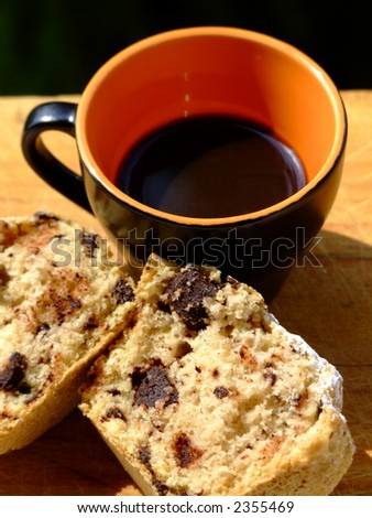 A cup of italian style black coffee and muffin with chocolate chips