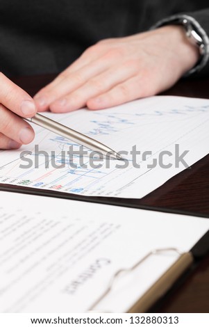 Business men reading contract with pen in hand