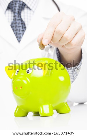 Doctor with green piggy bank as an idea for healthcare insurance and savings for medical expenses