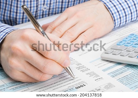 Male filling out 1040 United States of America Tax Form - studio shot