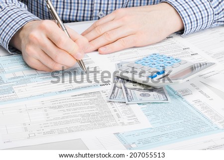 Male filling out 1040 USA Tax Form - studio shot