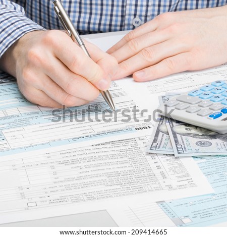 Male filling out 1040 USA Tax Form - studio shoot - 1 to 1 ratio