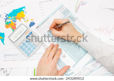 Business man with calculator and financial charts and graphs