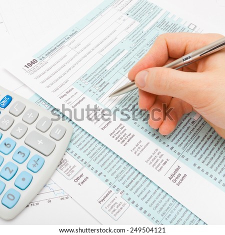 Filling out 1040 US Tax Form - studio shot
