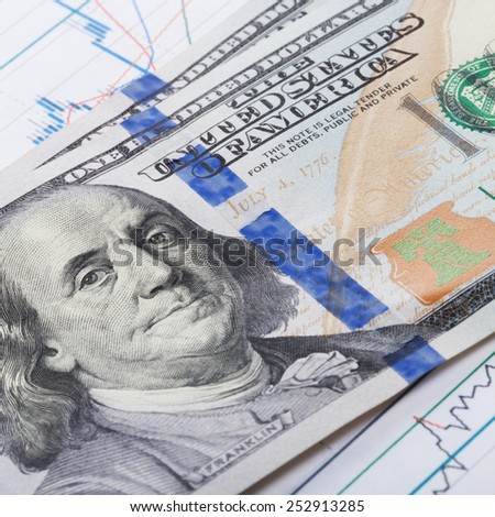 Hundred dollars banknote over stock market candle graph
