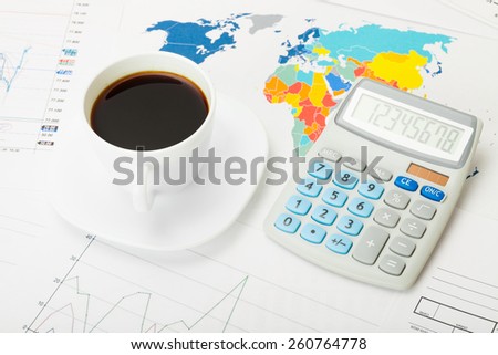 Coffee cup and calculator over world map and some financial charts