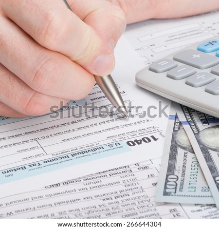 Taxpayer filling out USA 1040 Tax Form - close up shot