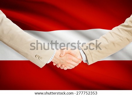 Businessmen shaking hands with flag on background - Austria