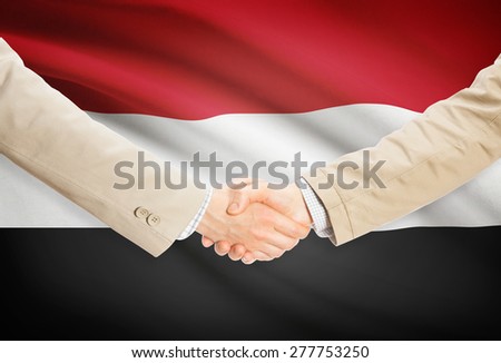 Businessmen shaking hands with flag on background - Yemen